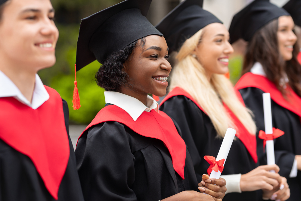 A student in a graduation cap and gown smiling